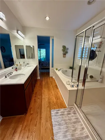 a spacious bathroom with a tub sink and mirror