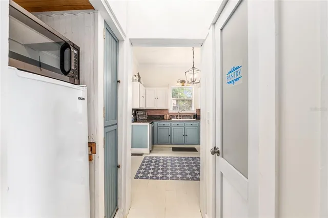 a kitchen with granite countertop white cabinets and white appliances