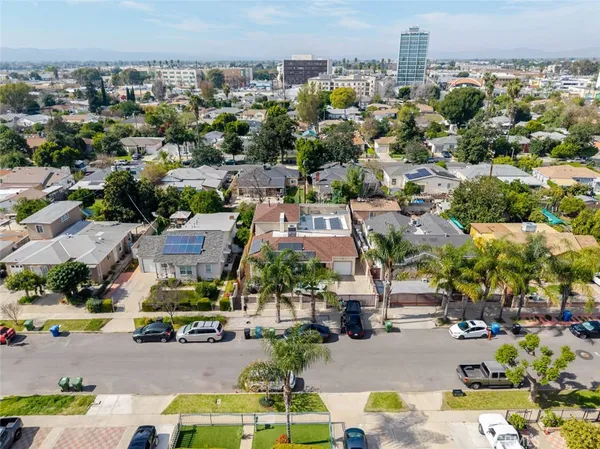 an aerial view of residential houses with outdoor space and parking