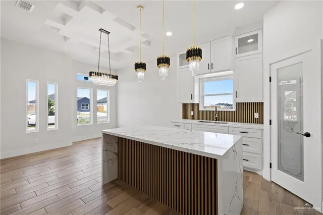 a kitchen with granite countertop a sink cabinets and wooden floor