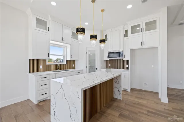a kitchen with white cabinets and sink