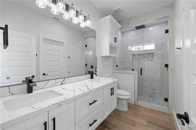 a spacious bathroom with a double vanity sink toilet and shower