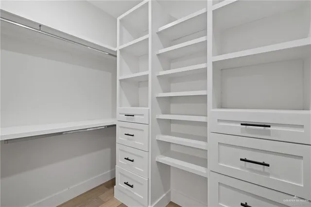 a view of walk in closet with empty racks