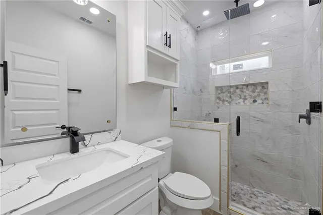 a bathroom with a sink a toilet and shower