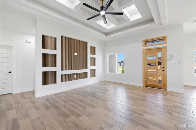 an empty room with wooden floor closet and windows