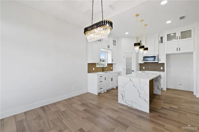 a large kitchen with white cabinets and stainless steel appliances