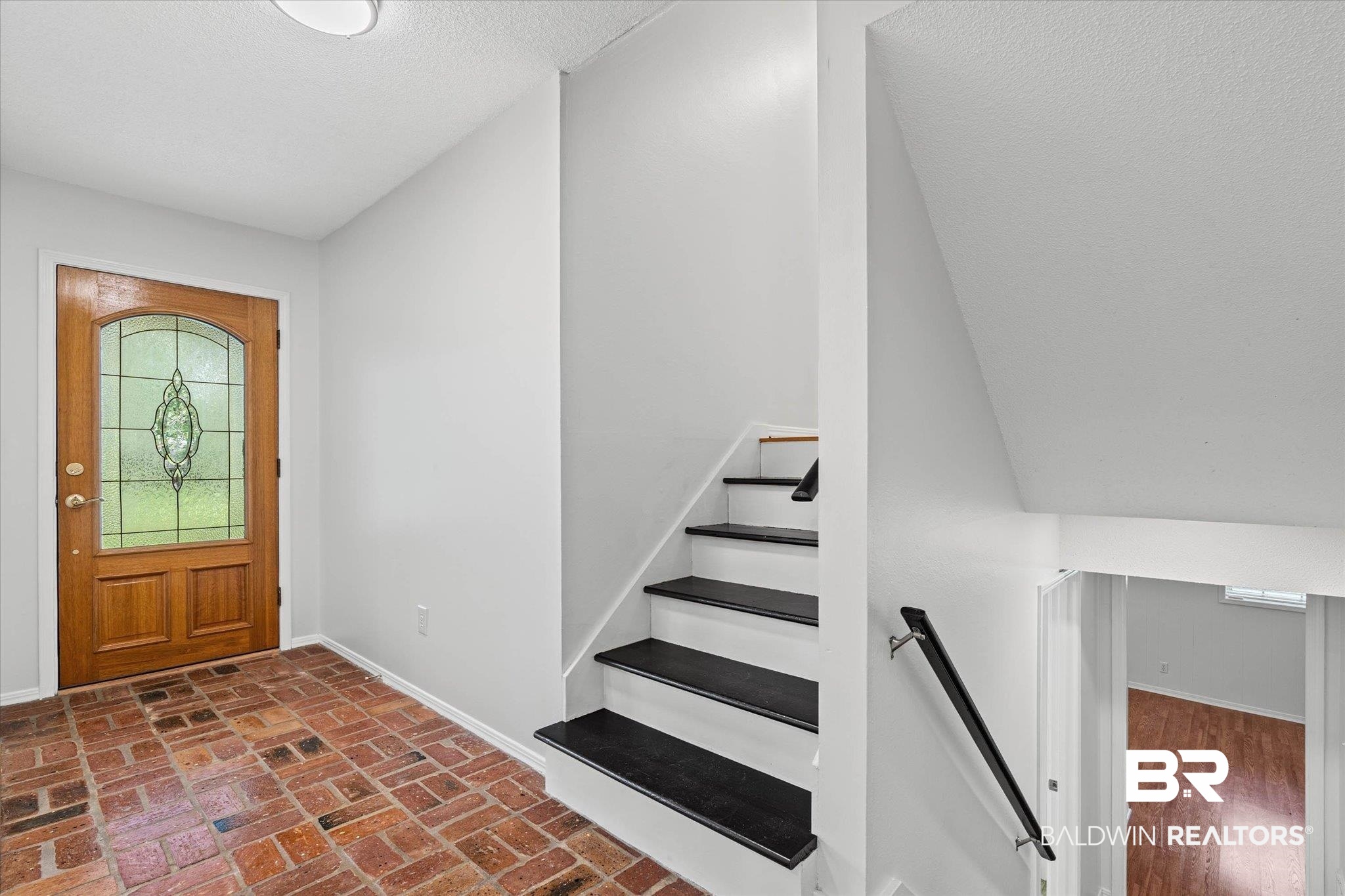 8301 Fordham Road Mobile, AL 36619 - Photo 3 of 57 Foyer featuring a wood entry door with decorative glass, brick-finish flooring, and light-toned walls
