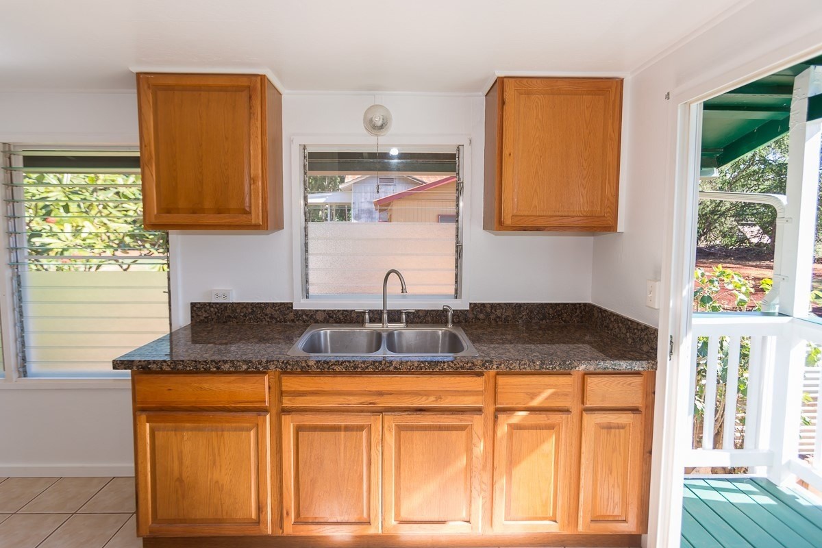4656 A Awawa Road, Unit 1 Hanapepe, HI 96705 - Photo 8 of 16 a bathroom with a granite countertop sink and a mirror