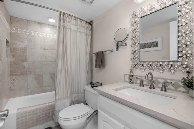 a bathroom with a granite countertop sink toilet and shower