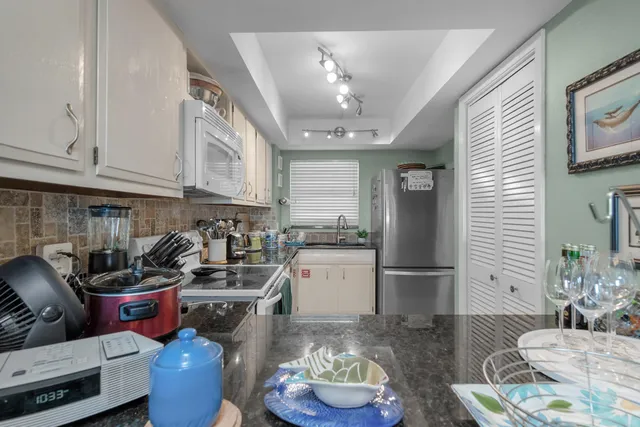 a kitchen with stainless steel appliances kitchen island granite countertop a refrigerator a stove a sink and dishwasher