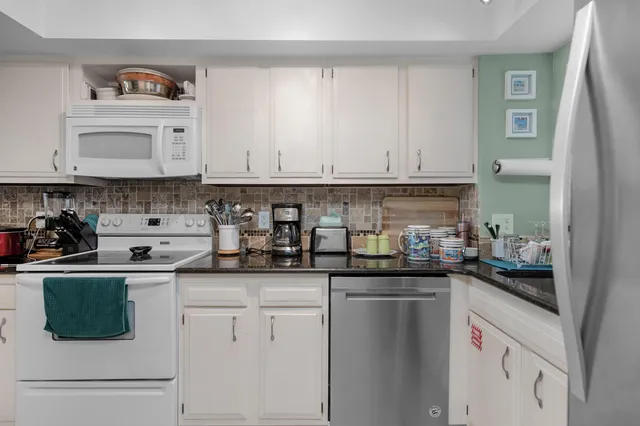 a kitchen with stainless steel appliances granite countertop a sink and cabinets