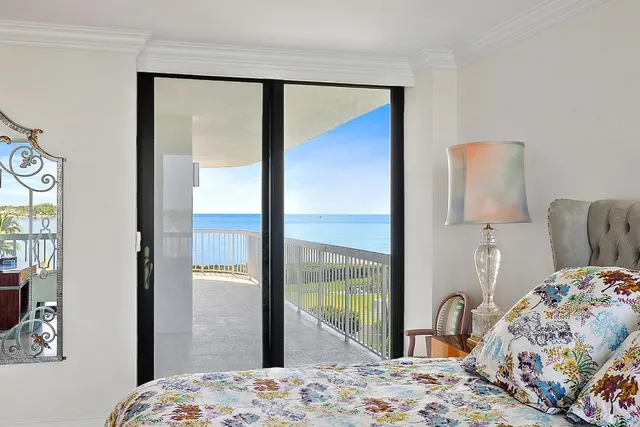 a bedroom with a bed and large windows