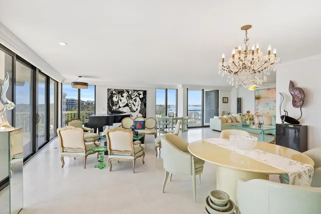 a dining room with furniture a chandelier and wooden floor
