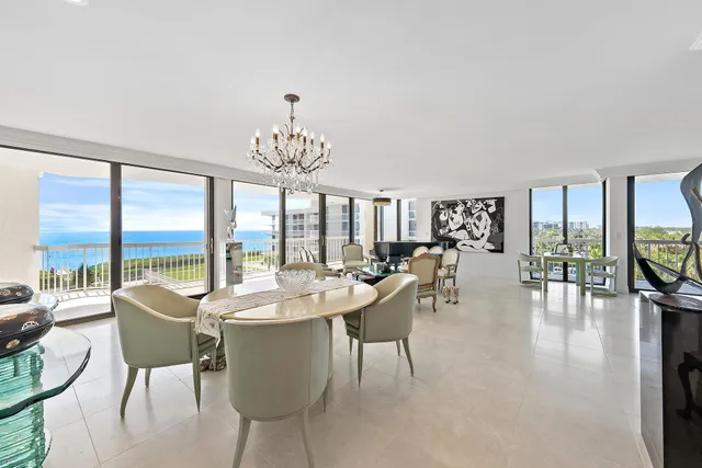 a dining room with furniture a chandelier and wooden floor