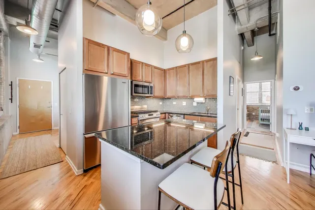 a kitchen with stainless steel appliances granite countertop a refrigerator sink and stove