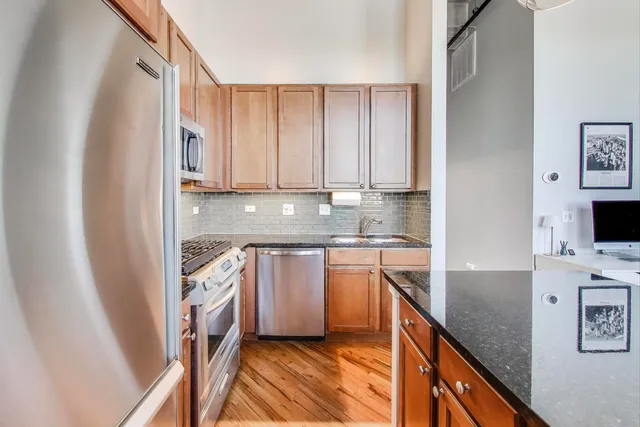 a kitchen with stainless steel appliances granite countertop a refrigerator sink and stove
