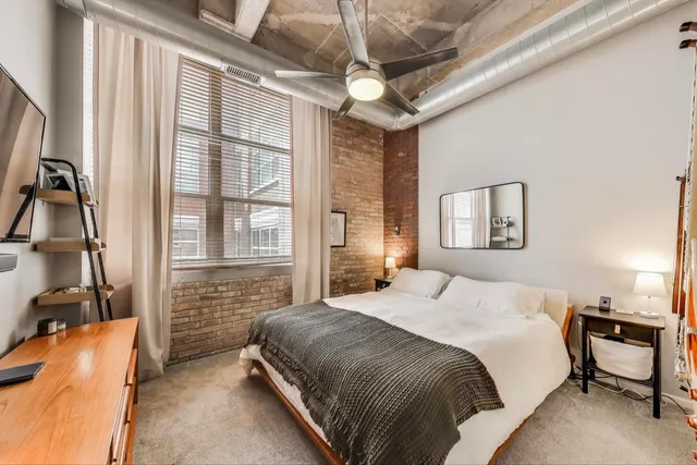 a bedroom with bed and ceiling fan