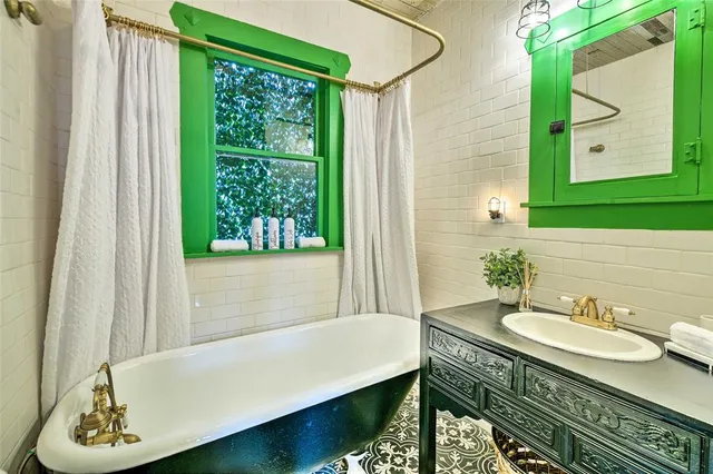 a bathroom with a granite countertop sink and a bathtub