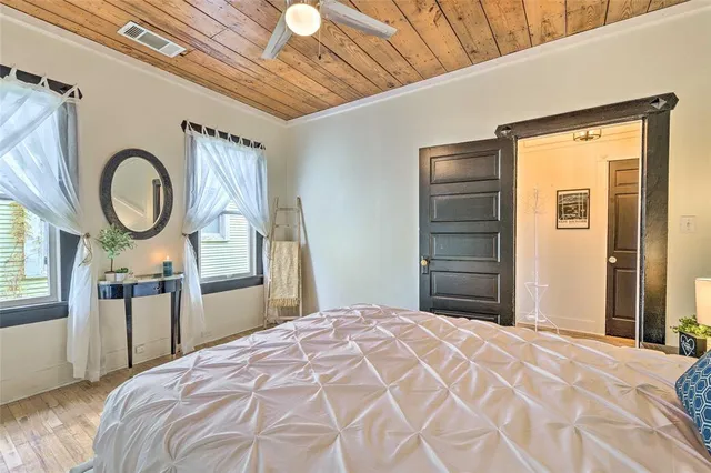 a bedroom with a bed mirror and a window