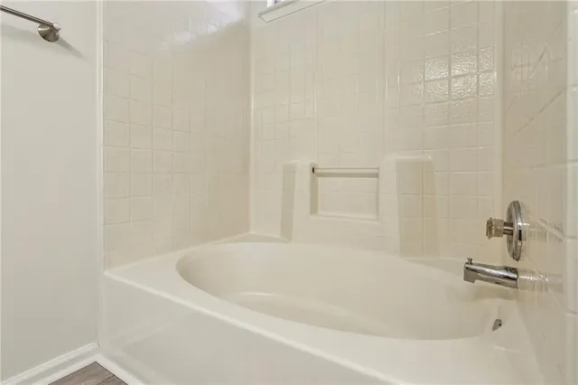 a white bath tub sitting next to a white sink and vanity
