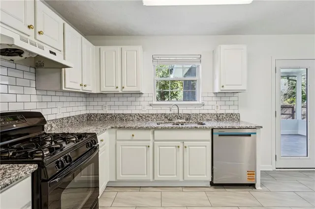 a kitchen with white cabinets and a stove top oven