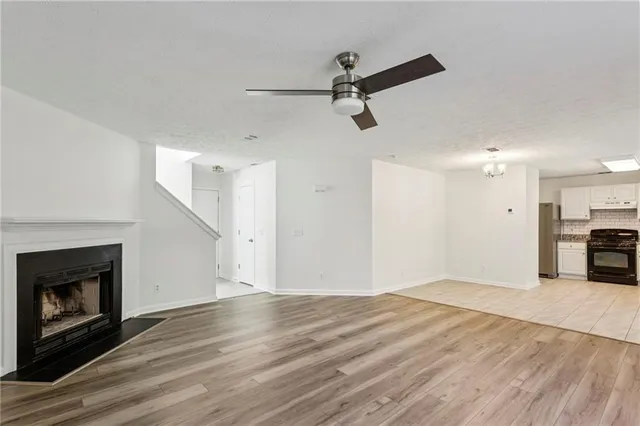 a view of empty room with wooden floor fireplace and windows