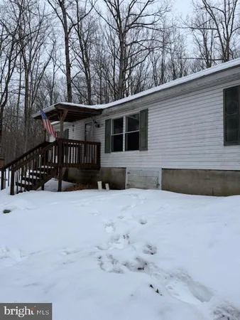 a front view of a house with a yard covered in snow