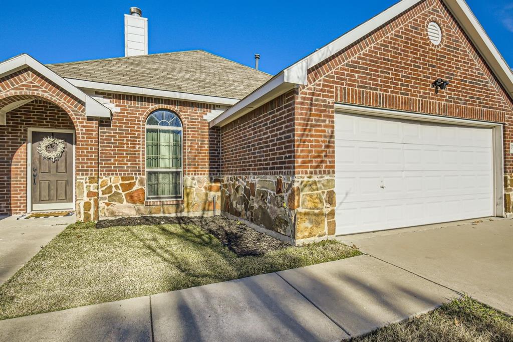 504 Thunder Trail Forney, TX 75126 - Photo 2 of 23 The property features an appealing brick exterior with stone accents, a concrete driveway, and an integrated garage