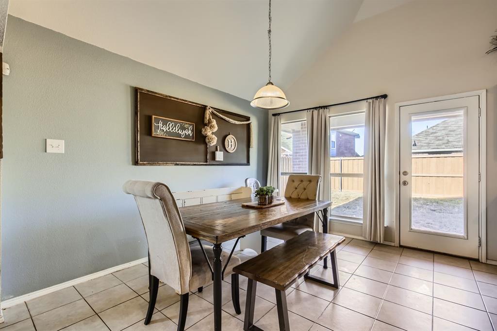504 Thunder Trail Forney, TX 75126 - Photo 6 of 23 Dining area with tiled flooring, a vaulted ceiling, and a glass-paneled door leading to the exterior