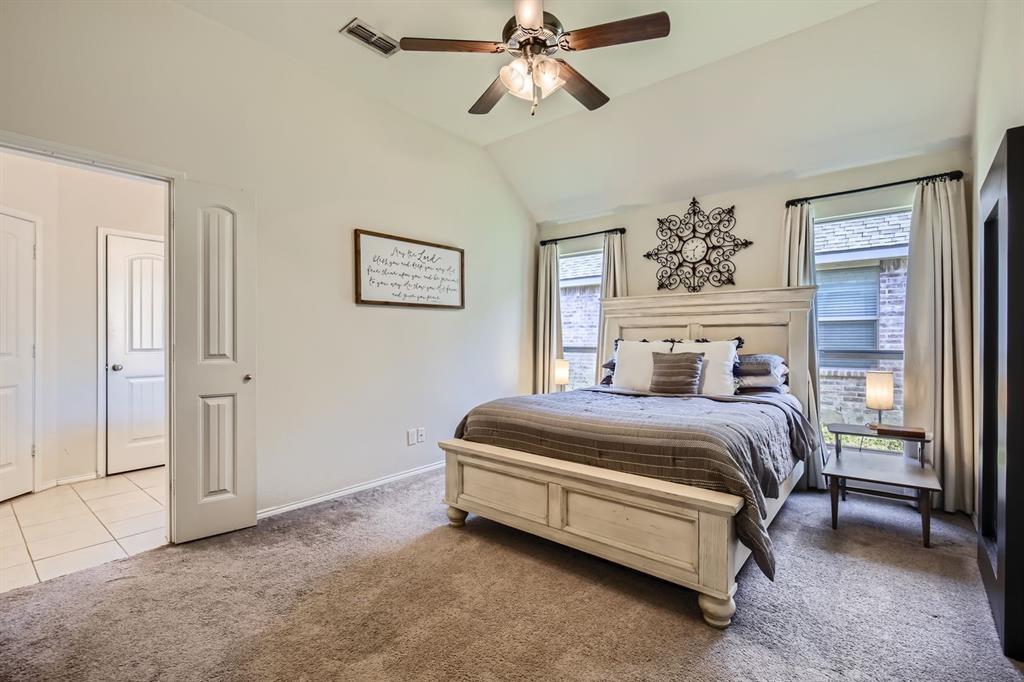 504 Thunder Trail Forney, TX 75126 - Photo 9 of 23 Bedroom featuring vaulted ceilings, a ceiling fan, carpeted flooring, and two windows providing natural light