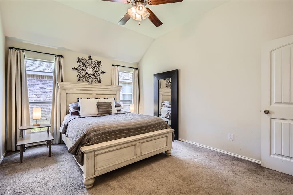 504 Thunder Trail Forney, TX 75126 - Photo 10 of 23 The bedroom features a vaulted ceiling, two windows with blinds and drapes, and carpeted flooring