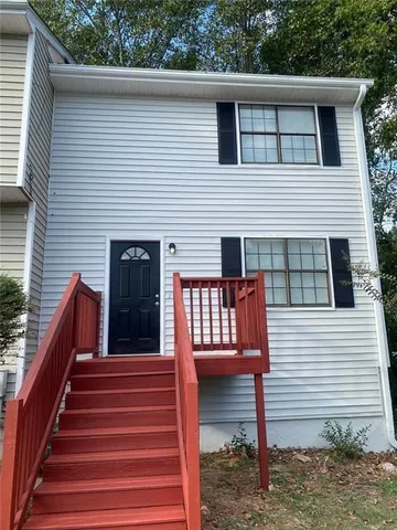a view of a house with wooden deck and a backyard