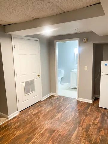a big room with wooden floor and bathroom view