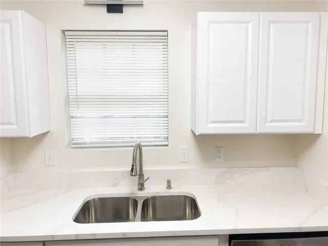 a kitchen with a sink cabinets and a window