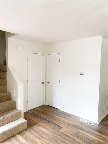 a view of a livingroom with wooden floor and white walls