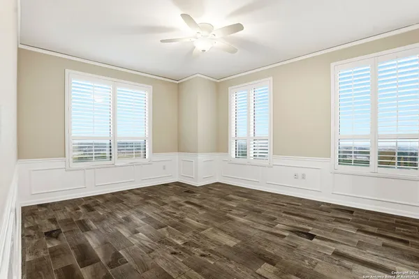 a view of an empty room with a window and a chandelier