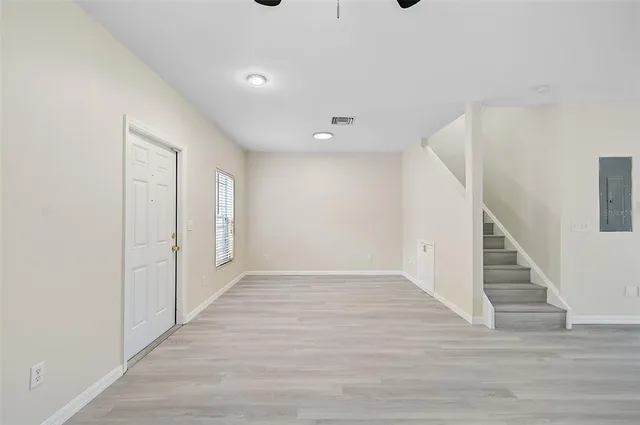 a view of an empty room with wooden floor