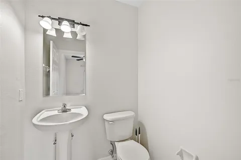a bathroom with a toilet a sink and a mirror