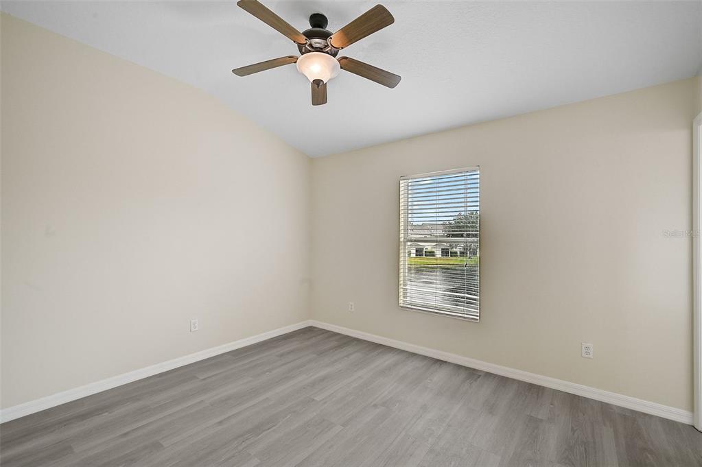 14939 Amberjack Terrace, Unit 102 Lakewood Ranch, FL 34202 - Photo 22 of 34 an empty room with wooden floor ceiling fan and windows