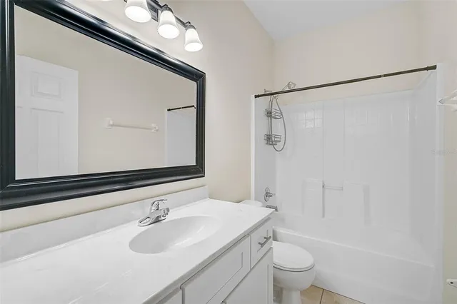 a bathroom with a sink a toilet a mirror and shower