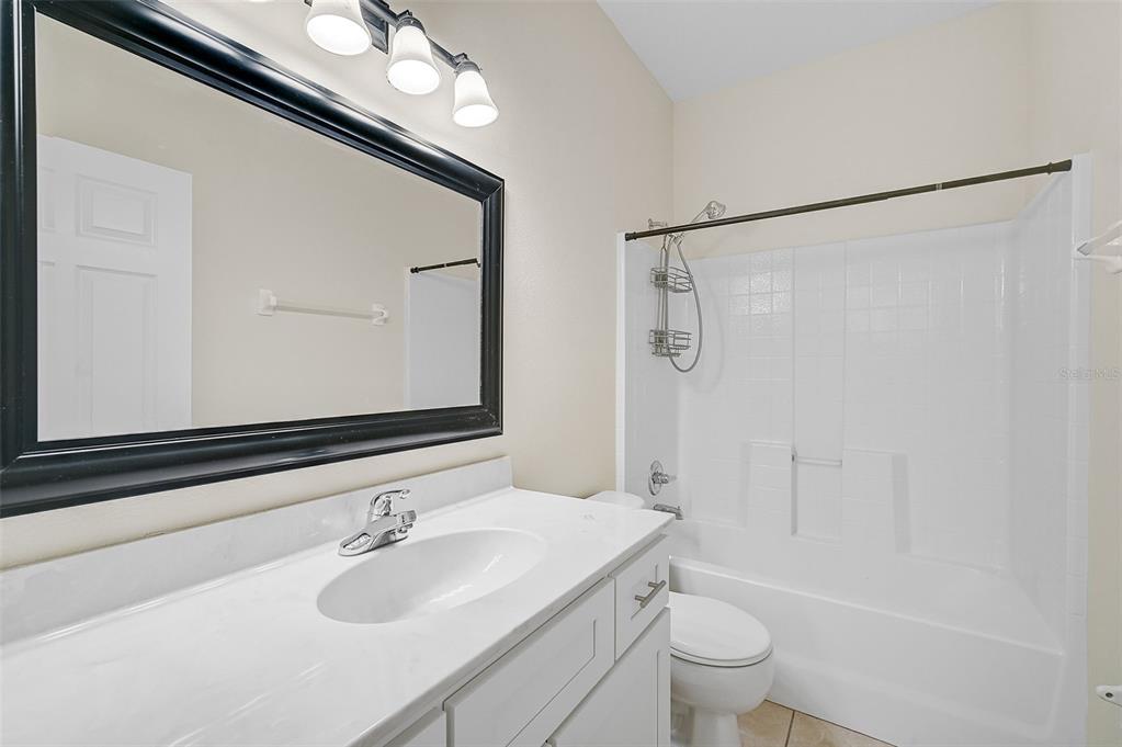 14939 Amberjack Terrace, Unit 102 Lakewood Ranch, FL 34202 - Photo 28 of 34 a bathroom with a sink a toilet a mirror and shower