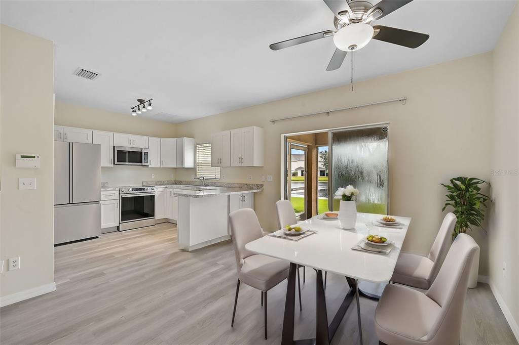 14939 Amberjack Terrace, Unit 102 Lakewood Ranch, FL 34202 - Photo 3 of 34 a view of a dining room with furniture and wooden floor