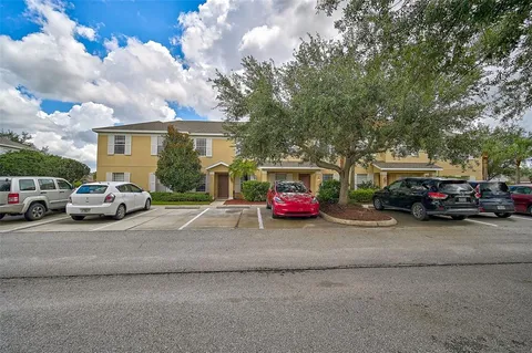 a view of road with card parked cars and trees