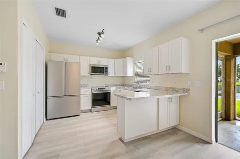 a kitchen with stainless steel appliances granite countertop a refrigerator sink and stove