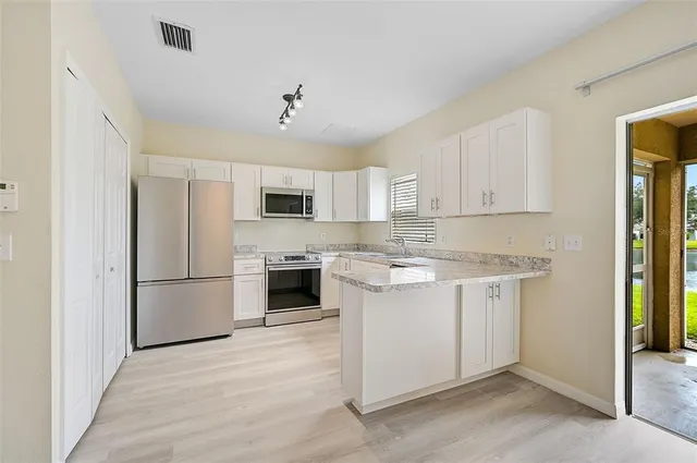 a kitchen with stainless steel appliances granite countertop a refrigerator sink and stove