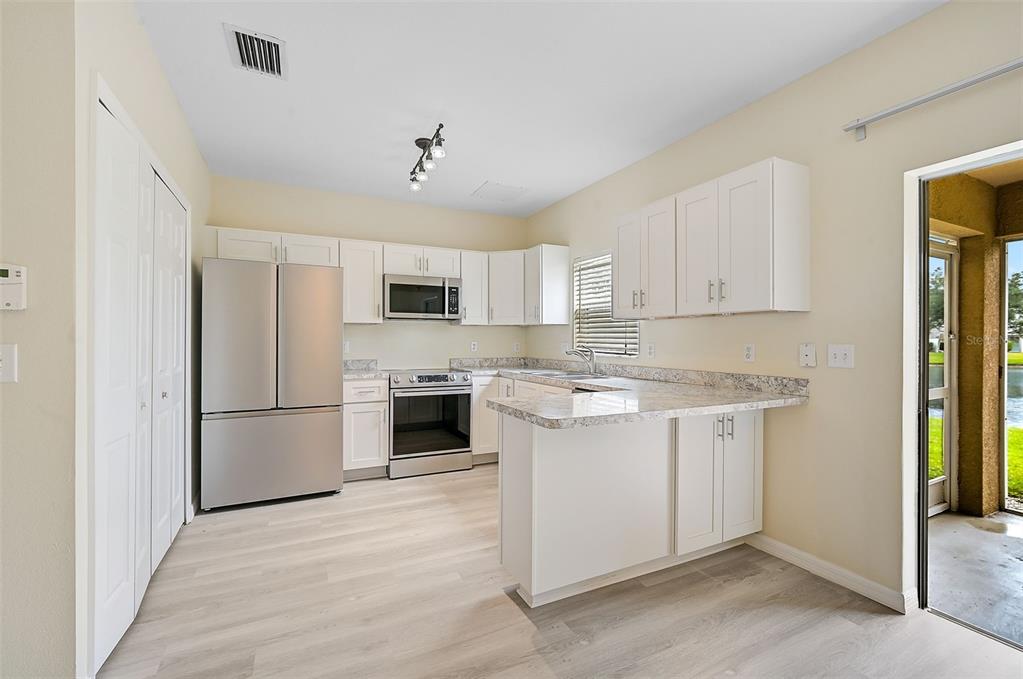 14939 Amberjack Terrace, Unit 102 Lakewood Ranch, FL 34202 - Photo 7 of 34 a kitchen with stainless steel appliances granite countertop a refrigerator sink and stove