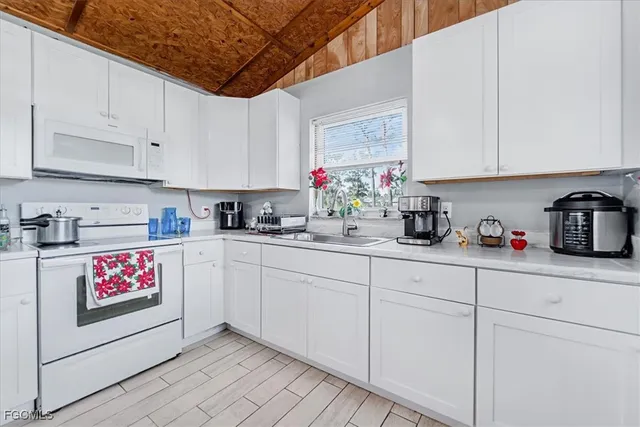 a kitchen with stainless steel appliances granite countertop a sink a stove and cabinets