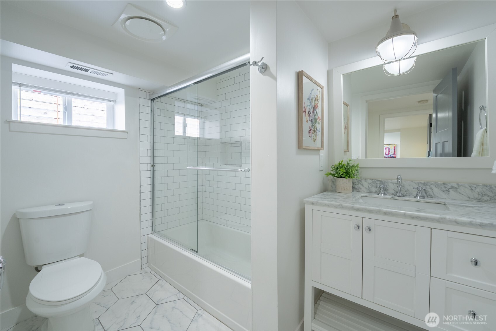 4418 40th Avenue Southwest Seattle, WA 98116 - Photo 32 of 40 a bathroom with a granite countertop sink a toilet a mirror and shower