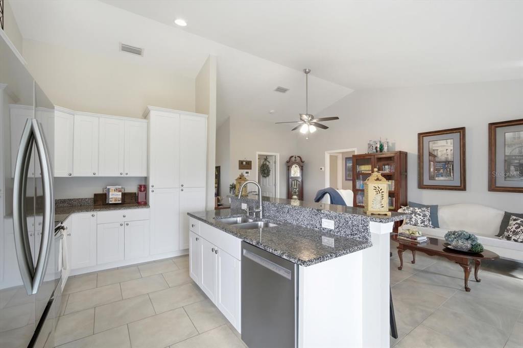 846 Birdie Way Apollo Beach, FL 33572 - Photo 12 of 31 a kitchen with stainless steel appliances kitchen island granite countertop a sink and cabinets
