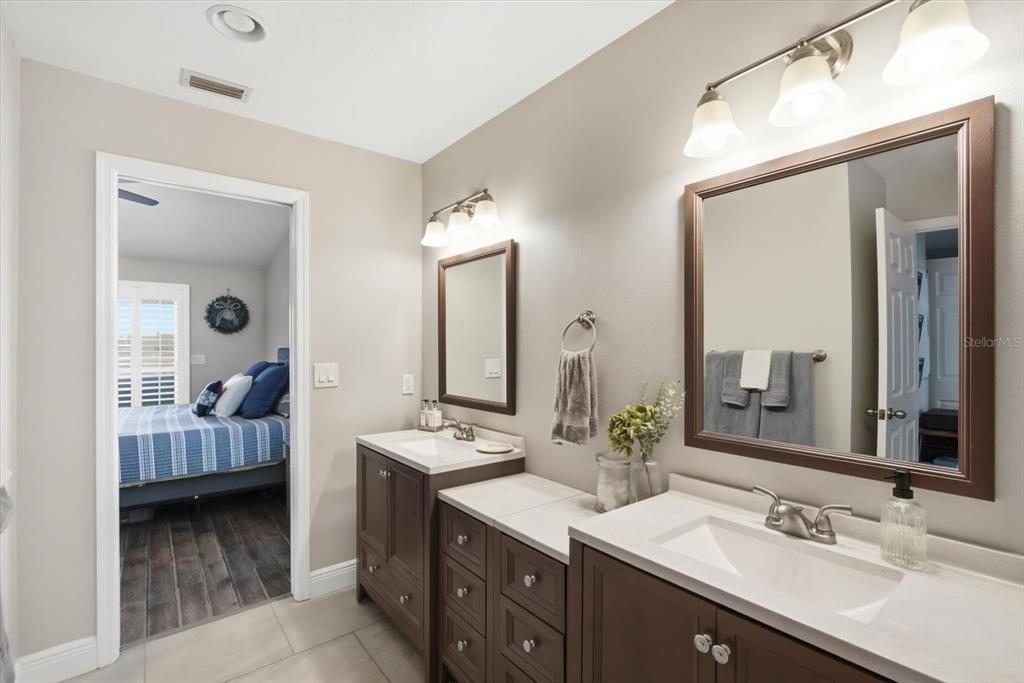 846 Birdie Way Apollo Beach, FL 33572 - Photo 16 of 31 a en suite bathroom with a double vanity sink and a mirror